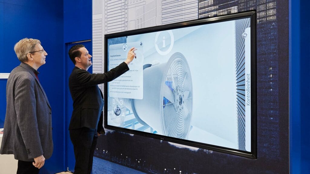 Two men using an HVAC interactive VR App on a large touchscreen